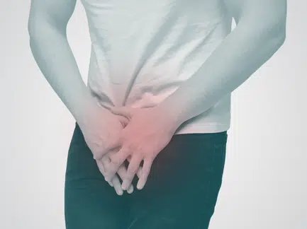 Man holding groin with red overlay for urology pain in Dubai